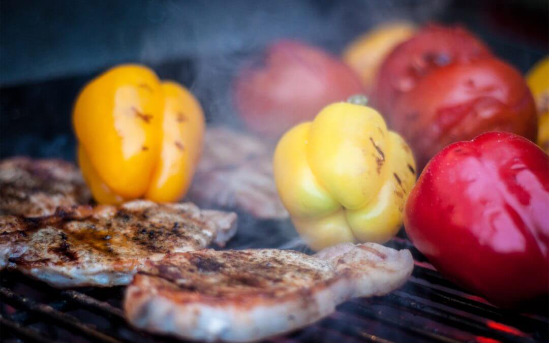 meat and peppers grilling on grill